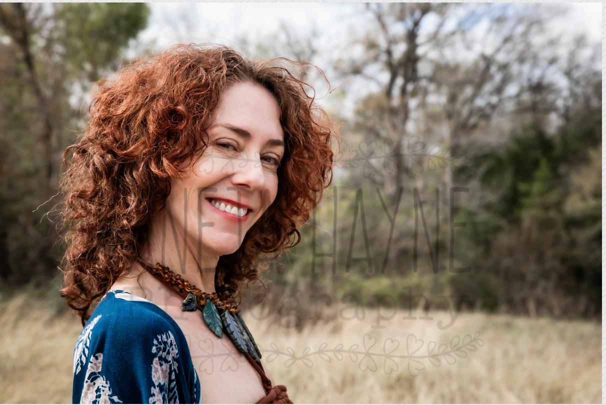 Close portrait of the practitioner smiling warmly in an open field