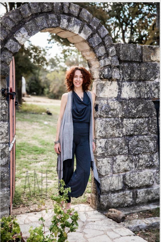 Portrait of the practitioner leaning against a stone archway